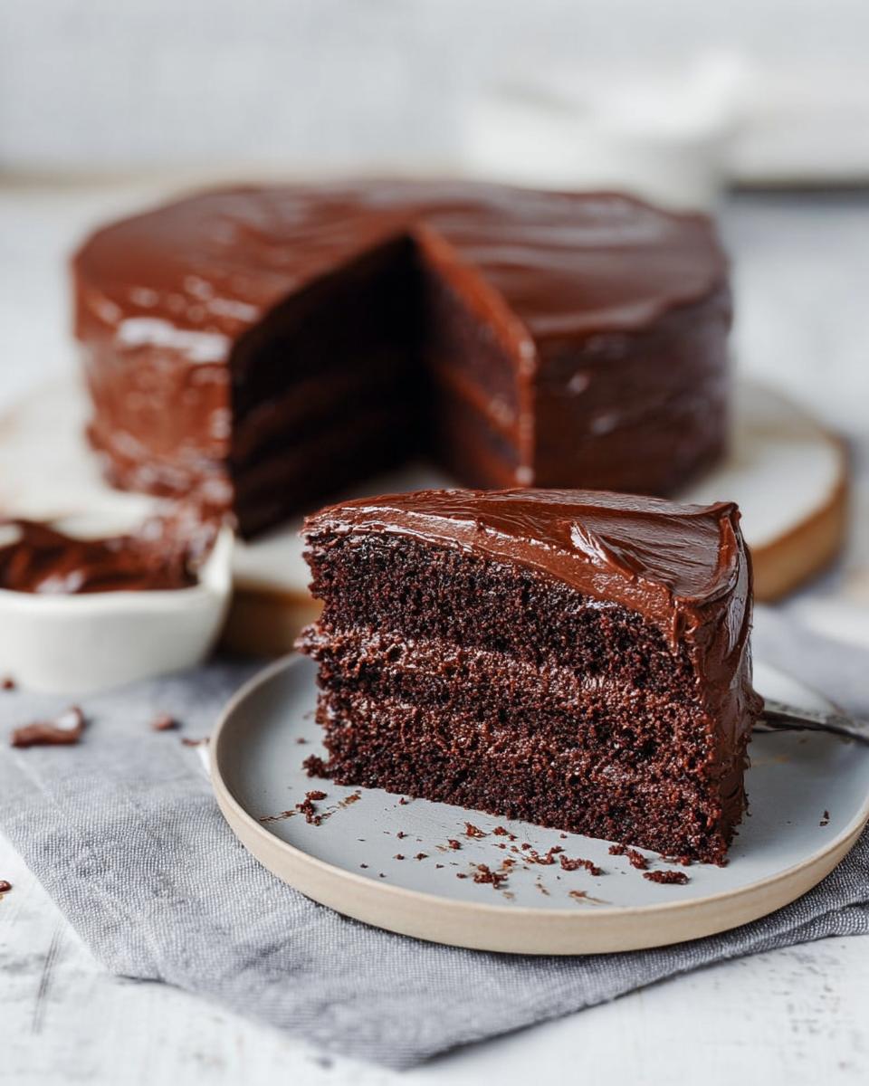 A slice of moist chocolate cake with rich chocolate frosting, part of 7-Ingredient Cake Ideas Recipes.