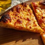 Close-up of three slices of cheese pizza, featuring melted golden cheese and a crispy crust, perfect for pizza night recipes.