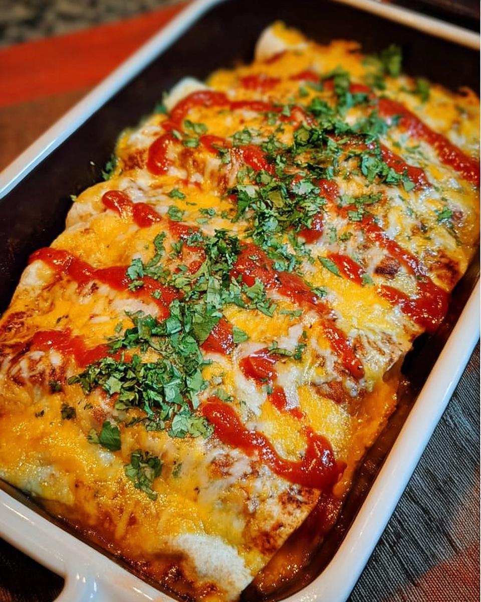A baking dish filled with cheesy chicken enchiladas, drizzled with sauce and topped with fresh cilantro.