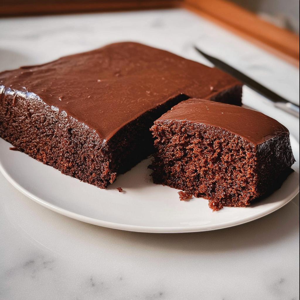 A slice of rich chocolate cake with smooth frosting, perfect for cake ideas recipes.
