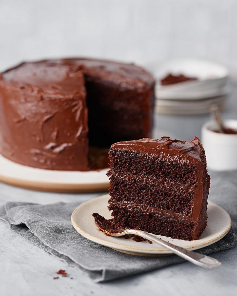 A slice of rich, moist chocolate cake with creamy frosting, part of 7-Ingredient Cake Ideas.