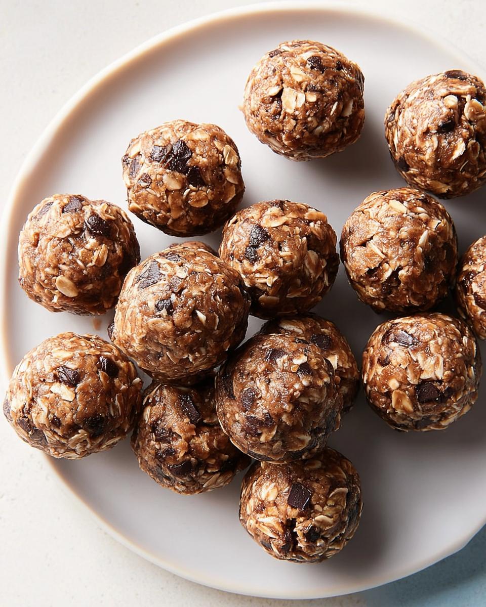 A pile of chocolate chip energy balls, perfect for breakfast ideas recipes, on a white plate.
