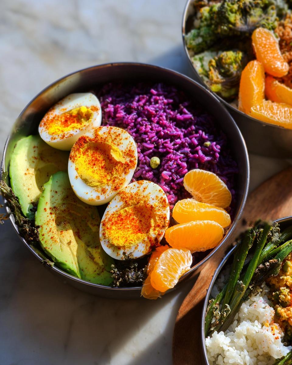 Close-up of a bowl with boiled eggs, purple rice, avocado slices, and orange segments, part of an egg recipe guide.