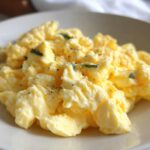 Close-up of fluffy scrambled eggs seasoned with black pepper and herbs, perfect for any egg recipe.