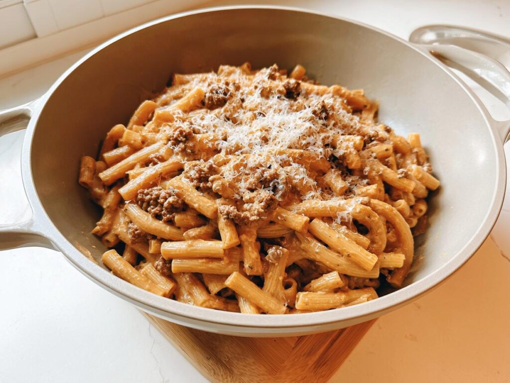 A bowl of rigatoni pasta with a rich meat sauce and grated cheese, perfect for busy weeknights.