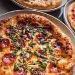 Close-up of a delicious pepperoni pizza with melted cheese and fresh basil, part of The Ultimate Pizza Night Recipes Guide.