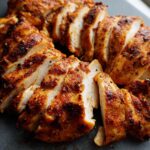 Close-up of sliced, seasoned restaurant-style air fryer chicken breast, juicy and golden brown.