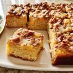 A slice of restaurant-style pecan streusel cake with a drizzle of icing, ready to be enjoyed.