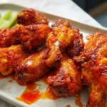 A plate of delicious, saucy chicken wings with celery sticks, perfect for busy weeknights.