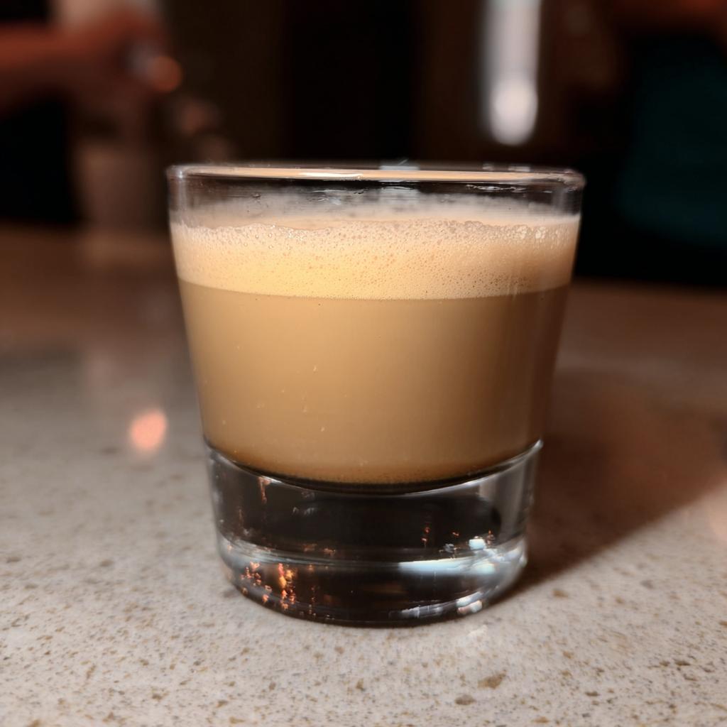 A close-up of a Starbucks espresso shot in a small glass with foamy crema on top, perfect for busy weeknights.