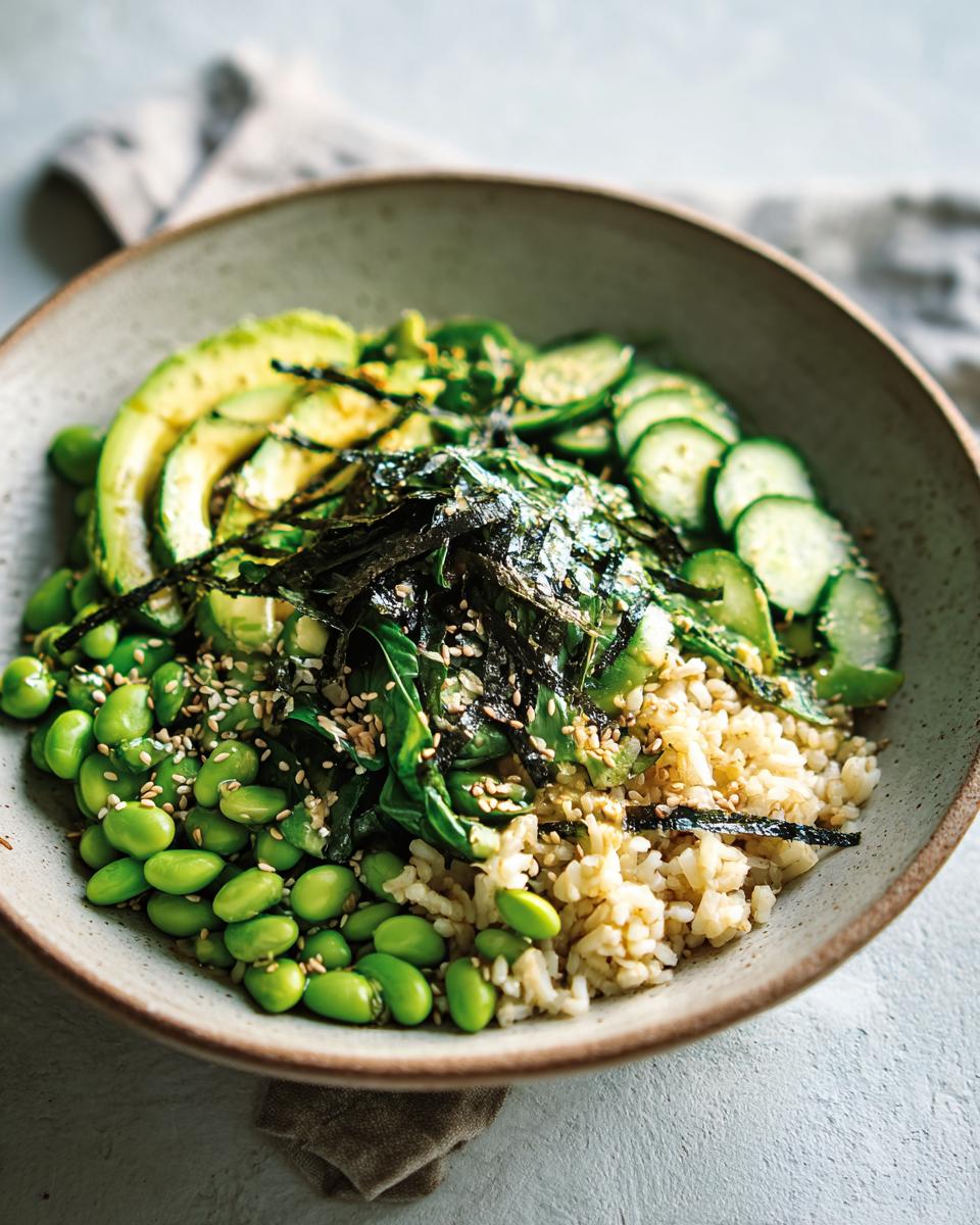 A vibrant rice bowl featuring brown rice, edamame, sliced avocado, cucumber, and nori seaweed, part of The Ultimate Rice Bowls Recipes Guide.