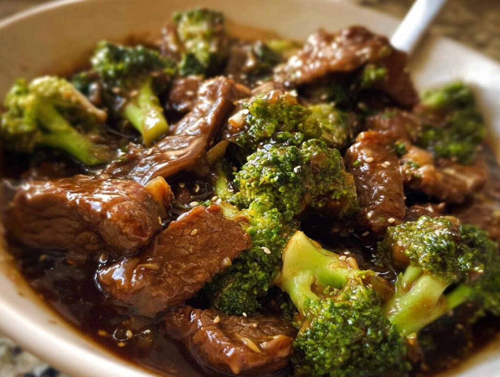 Close-up of a bowl of authentic Chinese Beef and Broccoli, featuring tender beef slices and vibrant broccoli florets in a savory sauce.