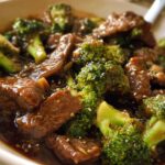 Close-up of a bowl of authentic Chinese Beef and Broccoli, featuring tender beef slices and vibrant broccoli florets in a savory sauce.