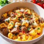 A bowl of Garlic Steak Tortellini with a rich, creamy sauce, garnished with parsley and Parmesan cheese.