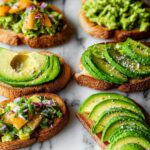 A variety of avocado toast options, including sliced avocado and mashed avocado with toppings.