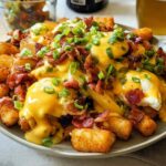 A hearty plate of Breakfast Poutine with Hollandaise Sauce, featuring crispy tater tots, poached eggs, bacon, and green onions.