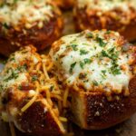 Close-up of an Easy Spaghetti Garlic Bread Bowl overflowing with spaghetti and topped with melted cheese and parsley.