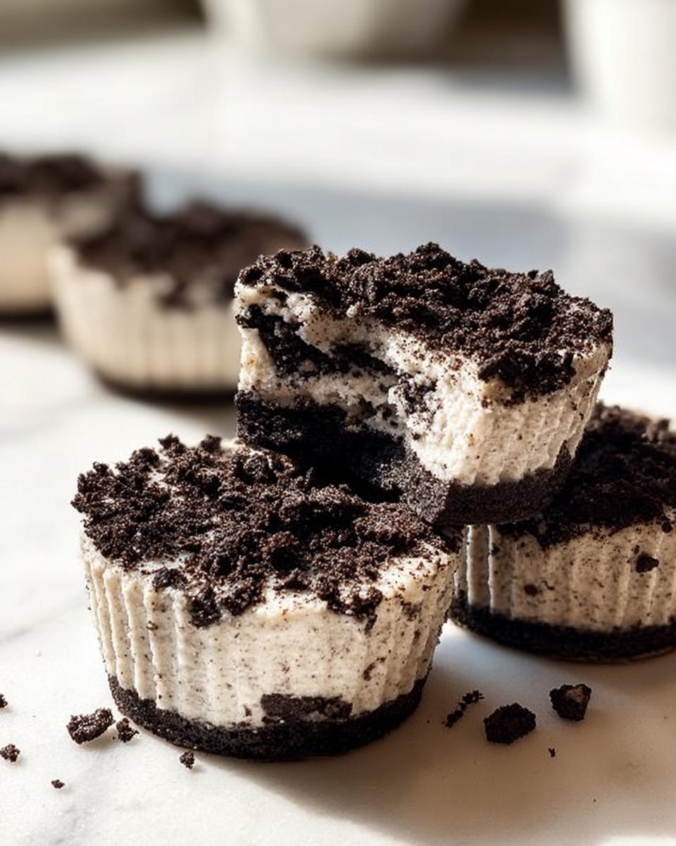 A close-up shot of Healthy No-Bake Oreo Cheesecake Bites, with one bite taken out, showing the creamy filling and cookie crust.