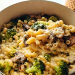 A spoonful of Healthy One Pot Broccoli Mac & Cheese with broccoli florets and mushrooms.