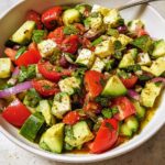 Close-up of a vibrant Mediterranean Avocado Egg Salad with tomatoes, cucumber, feta, and red onion.