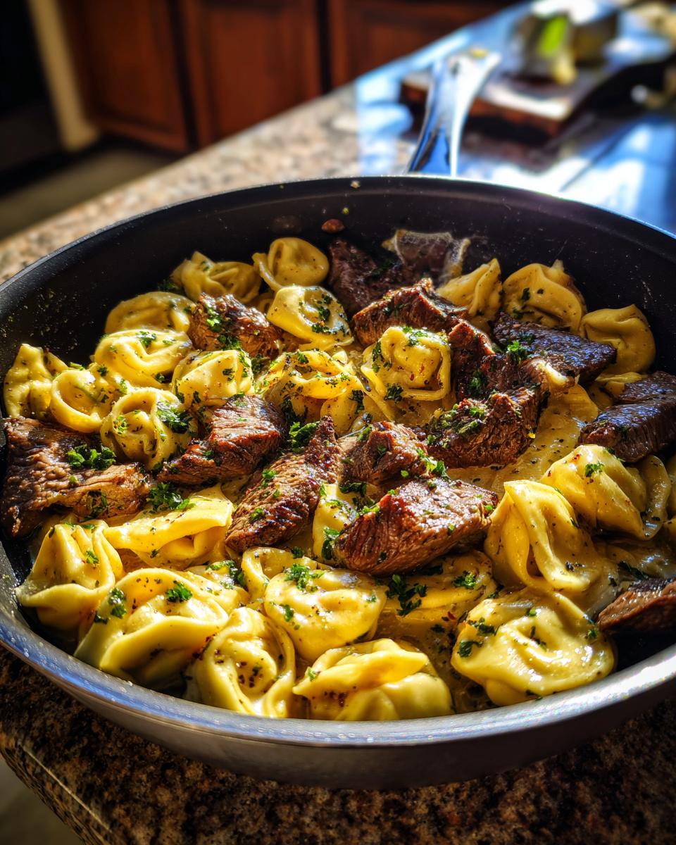 Close-up of Garlic Steak Tortellini in a skillet, garnished with fresh parsley.