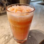 A refreshing glass of peach iced tea slush, perfect for hot afternoons.